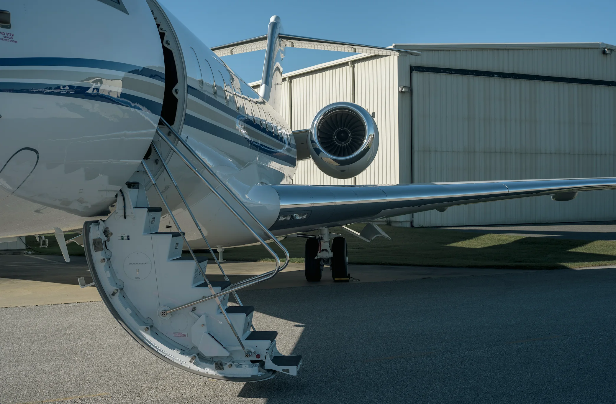 Private aircraft with boarding stairs in front of a hangar